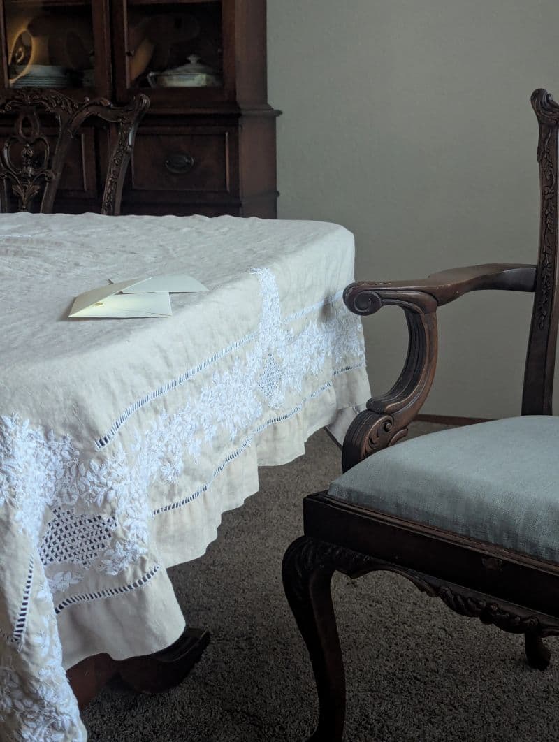 A handwritten note resting on a linen-covered dining table